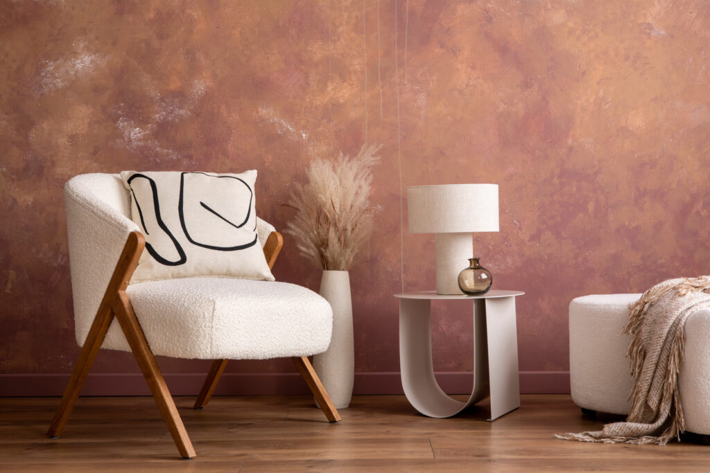 Interior design of living room interior with copy space white armchair, coffee table, lamp, vase with dried flowers and personal accessories. Home decor. Template.